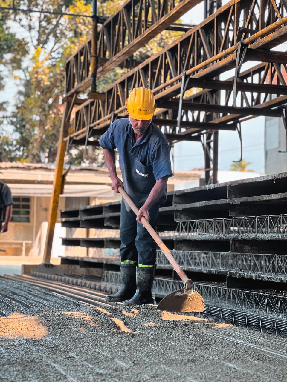Colaborador uniformizado Fortec finalizando capa de concreto